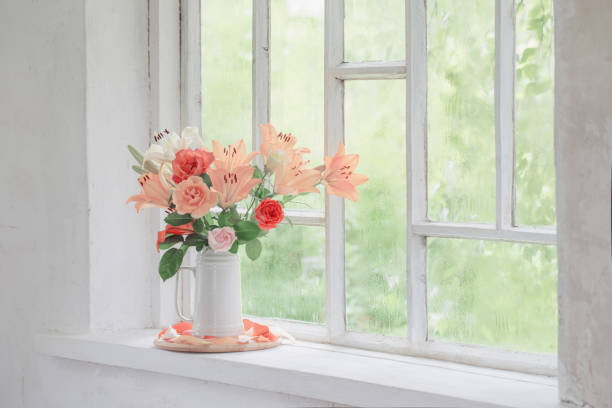 istock summer flowers in vase on background window with drops water 1256621198