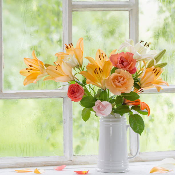 istock summer flowers in vase on background window with drops water 1256621201