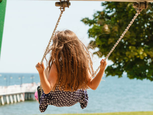 istock Girl swinging on swing-set. 1256622879
