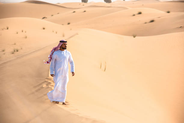 istock arabic man walking in the desert 1256625338