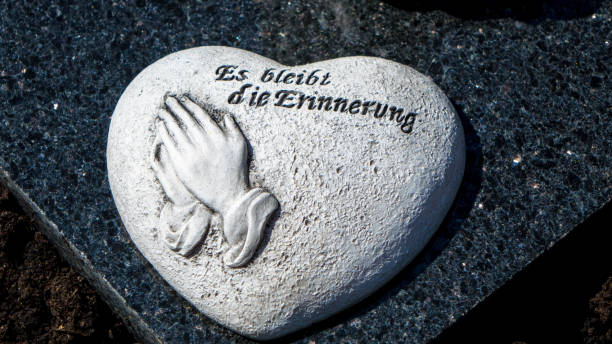 Mourning concept, heart shape with german text and praying hands