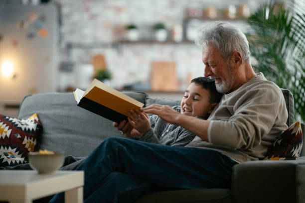 istock Grandfather and grandson reading a book. 1256627778