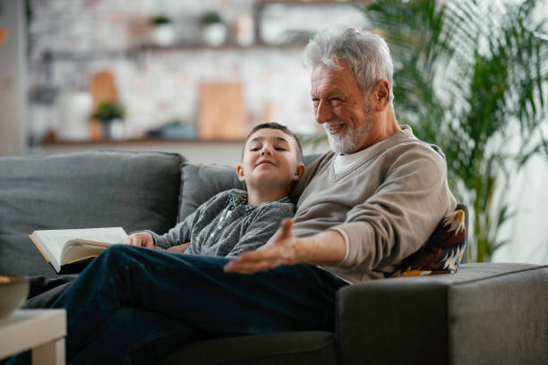 istock Grandfather and grandson reading a book. 1256627822
