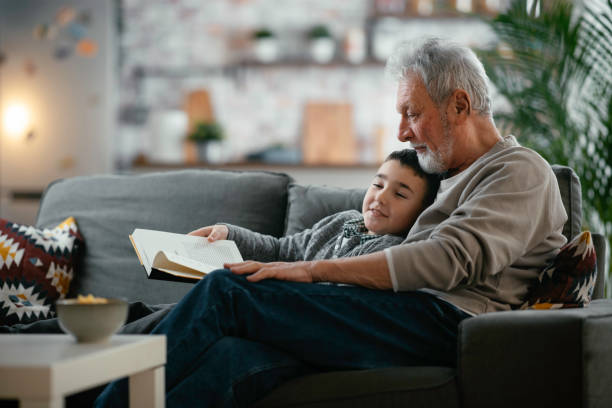istock Grandfather and grandson reading a book. 1256627841