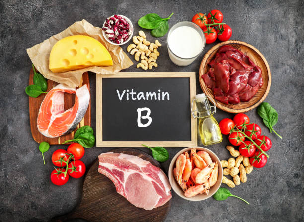 High vitamin B sources assortment Assortment of high vitamin B sources on dark background: milk, liver, olive oil, tomatoes, prawns, peanuts, beef, spinach, salmon, keshew, cheese, haricot. Top view. letter b stock pictures, royalty-free photos & images