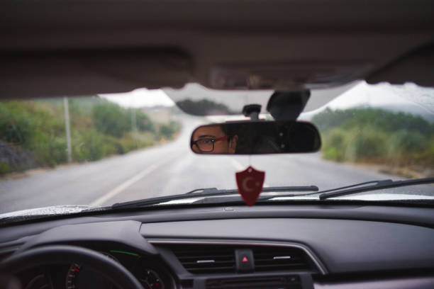 Woman driving in the rain with windshield wriper on