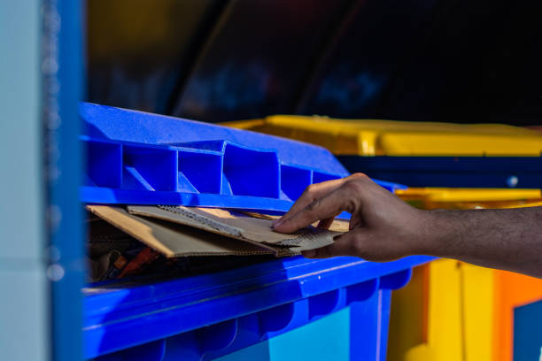 Close up hand throwing paper into recycle bin