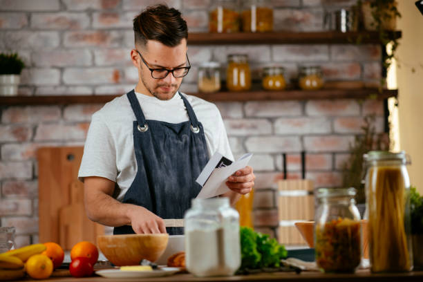 istock Young man preparing delicious food in kitchen. 1256635753