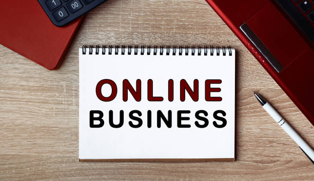 istock Notebook with text ONLINE BUSINESS. Notebook on desk with laptop and a pen. 1256635775