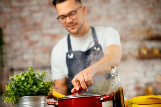 istock Young man preparing delicious food in kitchen. 1256635779