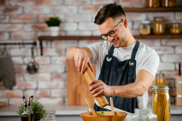 istock Young man preparing delicious food in kitchen. 1256635797