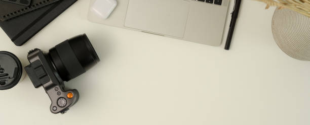 istock Photographer worktable with camera, laptop, stationery and copy space on white table 1256636260