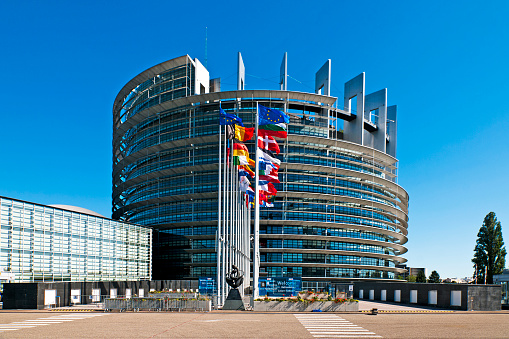 The European Parliament building in Strasbourg, France with flags waving calmly celebrating peace of the Europe. July 12, 2020.