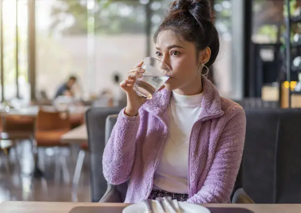 beautiful woman drinking a glass of water in restaurant
