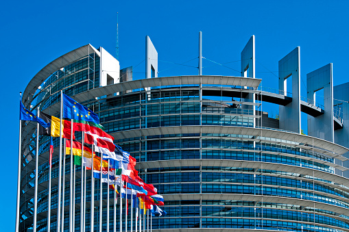 The European Parliament building in Strasbourg, France with flags waving calmly celebrating peace of the Europe. July 12, 2020.