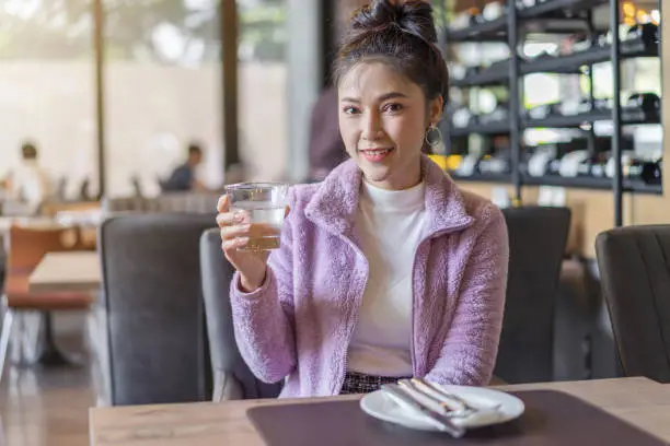 beautiful woman drinking a glass of water in restaurant