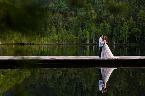 Happy newlyweds in the summer on the lake