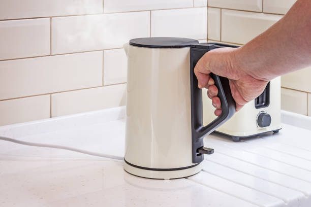 istock boiling electric kettle in hand in the kitchen 1256642843