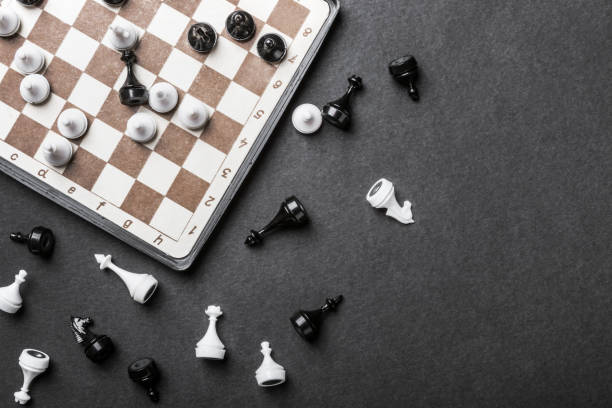 istock chessboard and chess pieces in a played game on a black background 1256643433