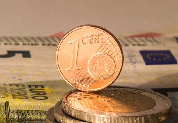 istock One Cent coin, euro bank notes and coins with white background. 1256643885