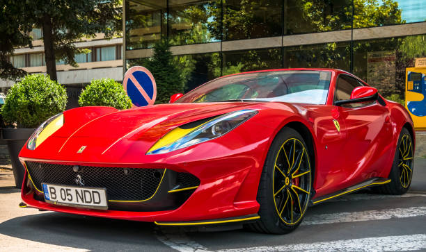 uma ferrari 812 superfast vermelha estacionou em frente ao aro palace hotel. - rodas ferrari - fotografias e filmes do acervo