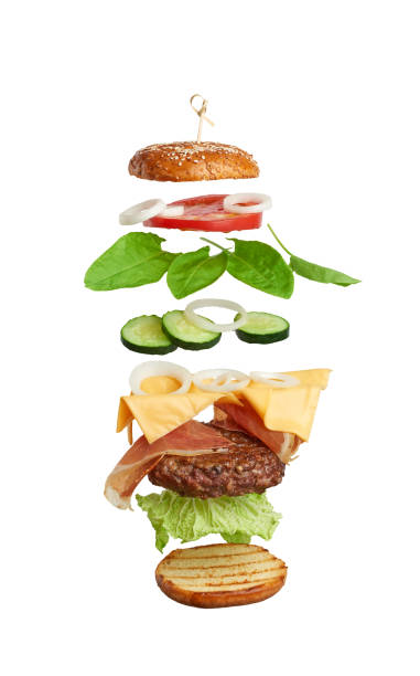 istock levitating cheeseburger ingredients: juicy meat cutlet, cheddar cheese, sesame bun, lettuce, white onion rings, slice of tomato, cucumber 1256645029
