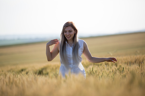 Woman with blonde hair relaxing in the meadow during sunset