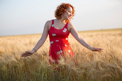 Woman with redhead relaxing in the meadow during sunset