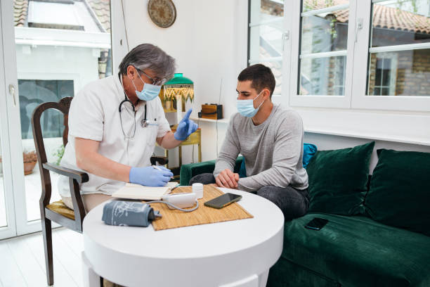 istock Doctor in a home visit to a young man 1256648057