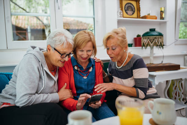 istock Female senior friends using cellphone 1256650600