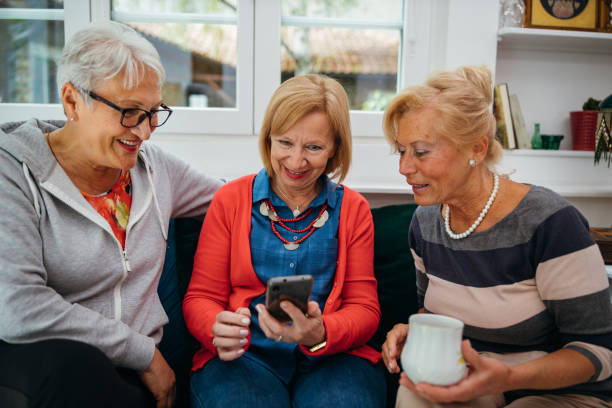 istock Female senior friends using cellphone 1256650613