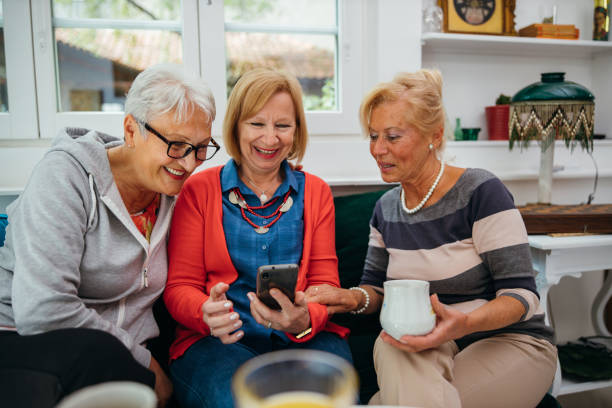 istock Female senior friends using cellphone 1256650698