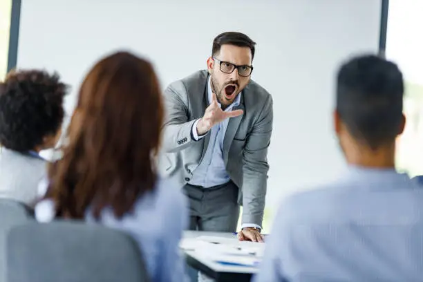 Photo of Angry CEO arguing with his colleagues on a presentation in the office.