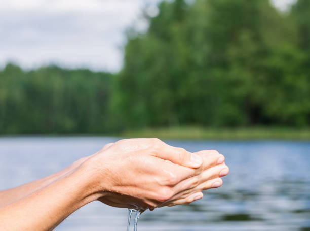 istock Person taking raw unfiltered water from a lake by hands 1256653569