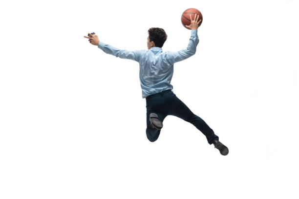 Man in office clothes playing basketball on white background. Unusual look for businessman in motion, action. Sport, healthy lifestyle. In jump. Man in office clothes playing basketball on white background like professional player, sportsman. Unusual look for businessman in motion, action with ball. Sport, healthy lifestyle, creativity. unusual basket stock pictures, royalty-free photos & images