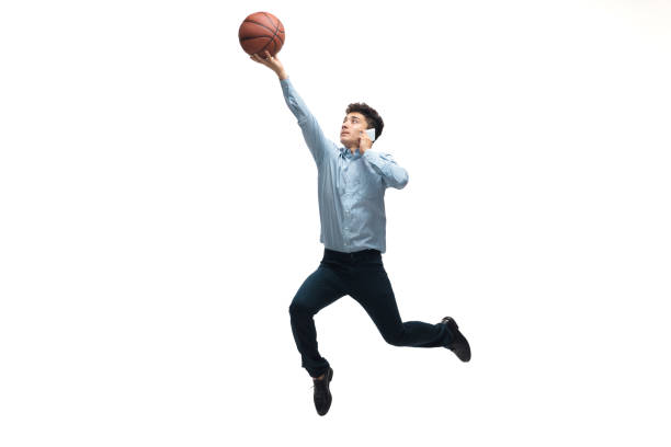 Man in office clothes playing basketball on white background. Unusual look for businessman in motion, action. Sport, healthy lifestyle. Leader. Man in office clothes playing basketball on white background like professional player, sportsman. Unusual look for businessman in motion, action with ball. Sport, healthy lifestyle, creativity. unusual basket stock pictures, royalty-free photos & images