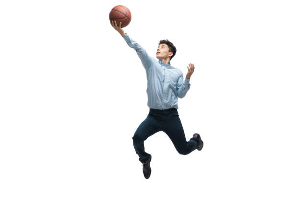Man in office clothes playing basketball on white background. Unusual look for businessman in motion, action. Sport, healthy lifestyle. In jump. Man in office clothes playing basketball on white background like professional player, sportsman. Unusual look for businessman in motion, action with ball. Sport, healthy lifestyle, creativity. unusual basket stock pictures, royalty-free photos & images