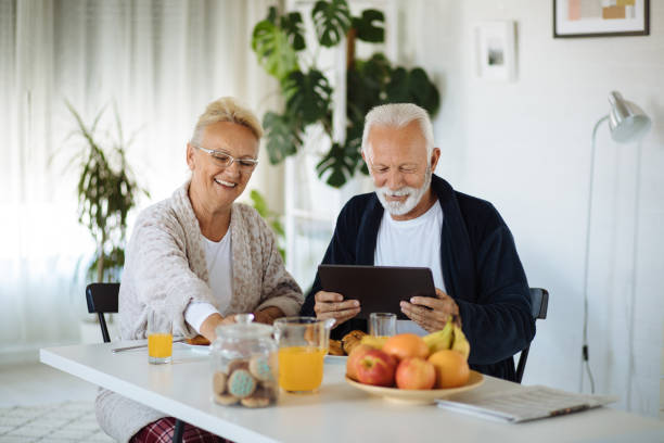 istock Older couple looking at digital tablet over breakfast at home 1256657106