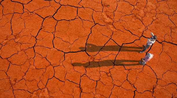 istock Two people on a dried up soil 1256657296