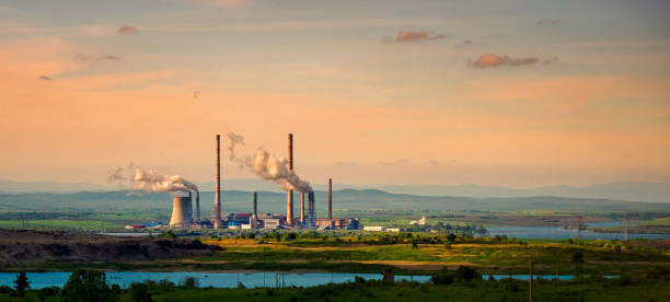 Industrial landscape with a fuel generation plant, smoke tubes and lake, wide landscape. stock photo