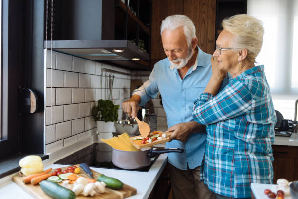 istock Senior couple in the kitchen preparing a meal 1256660915