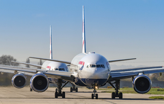 London, England - March 2019: Boeing 777 long haul airliners operated by British Airways taxiing for take off. The aircraft are used on long haul routes.