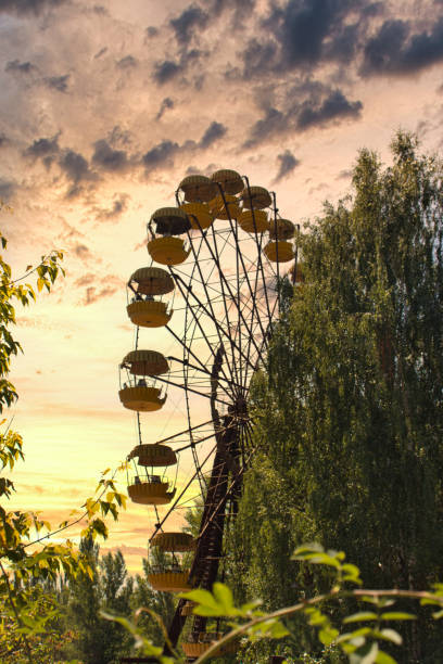 Iconic pripyat ferris wheel in the exclusion zone on a golden red sunset in the summer. Red almost burning sky indicating recent forest and wildfires Iconic pripyat ferris wheel in the exclusion zone on a golden red sunset in the summer. Red almost burning sky indicating recent forest and wildfires pripyat city stock pictures, royalty-free photos & images