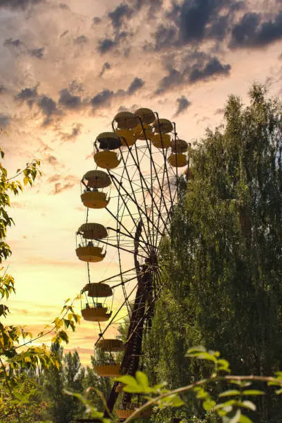 Iconic pripyat ferris wheel in the exclusion zone on a golden red sunset in the summer. Red almost burning sky indicating recent forest and wildfires