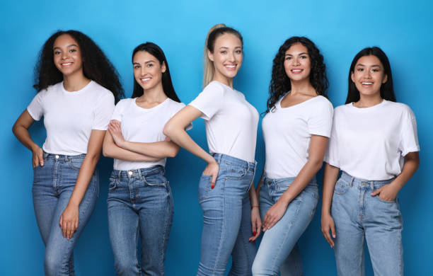 istock Pretty Multicultural Girls Smiling Standing On Blue Studio Background 1256668943