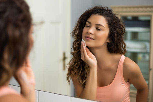 istock Woman cleaning her face with cotton pad 1256669016