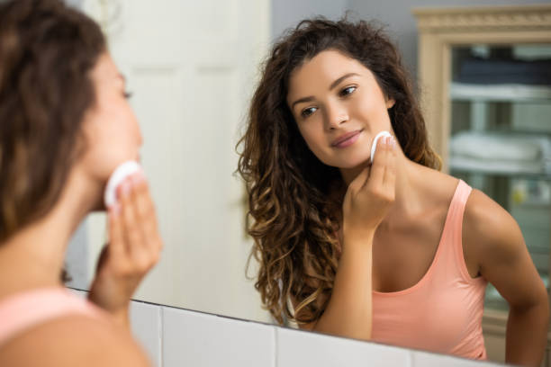 istock Woman cleaning her face with cotton pad 1256669025