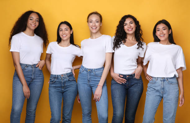 istock Five Multiethnic Models Girls Smiling Standing In Studio, Yellow Background 1256669411