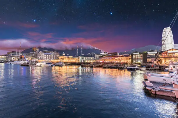 Cape Town waterfront lit up at night with stars in the sky