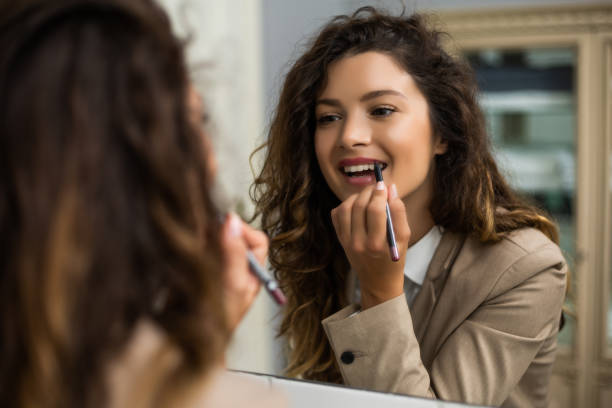 istock Woman applying lipstick 1256671322